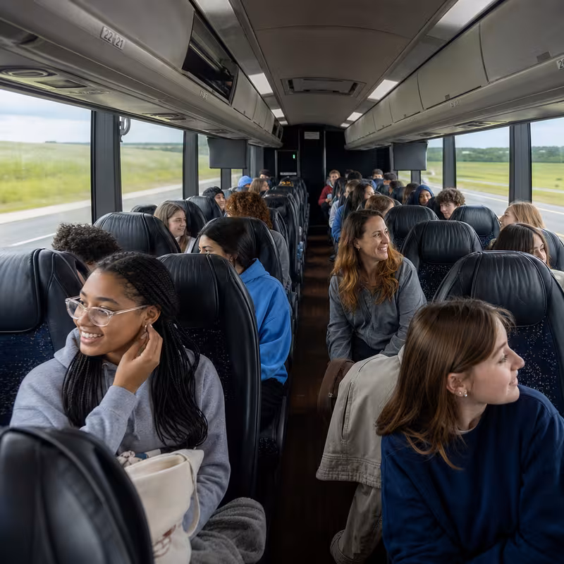 Group boarding a white charter bus for School Transportation transportation in Chicago